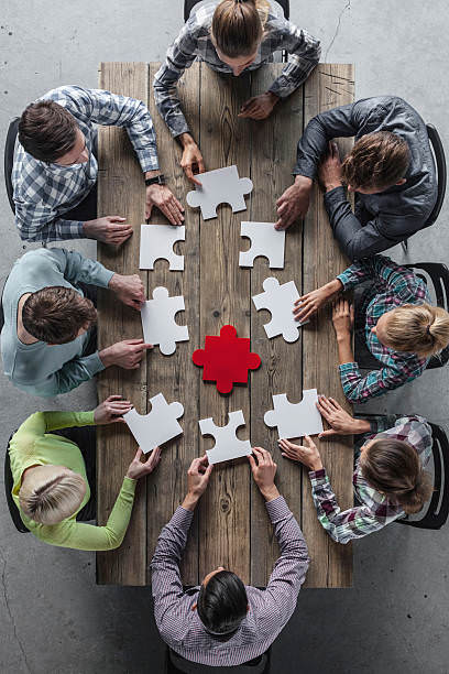 Un groupe de personnes assises autour d'une table avec des pièces de puzzle